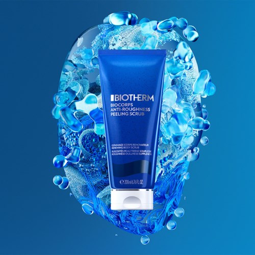 En blå tub med Biotherm Biocils Anti-Roughness Peeling Scrub med vatten och bubblor runt den.