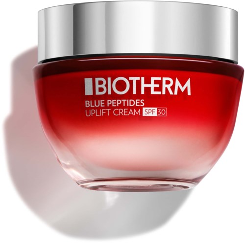 En rød krukke med Biotherm ansigtcreme med sølvhætte og SPF 30-mærke.