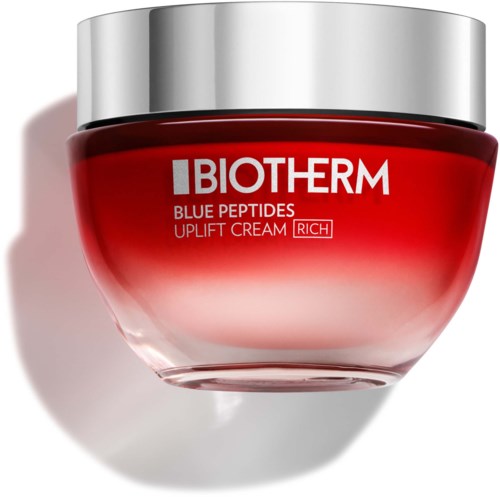 EnKruse med BIOTHERM Blue Peptides Uplift Cream, rød og sølv emballage, med skygge på overfladen.