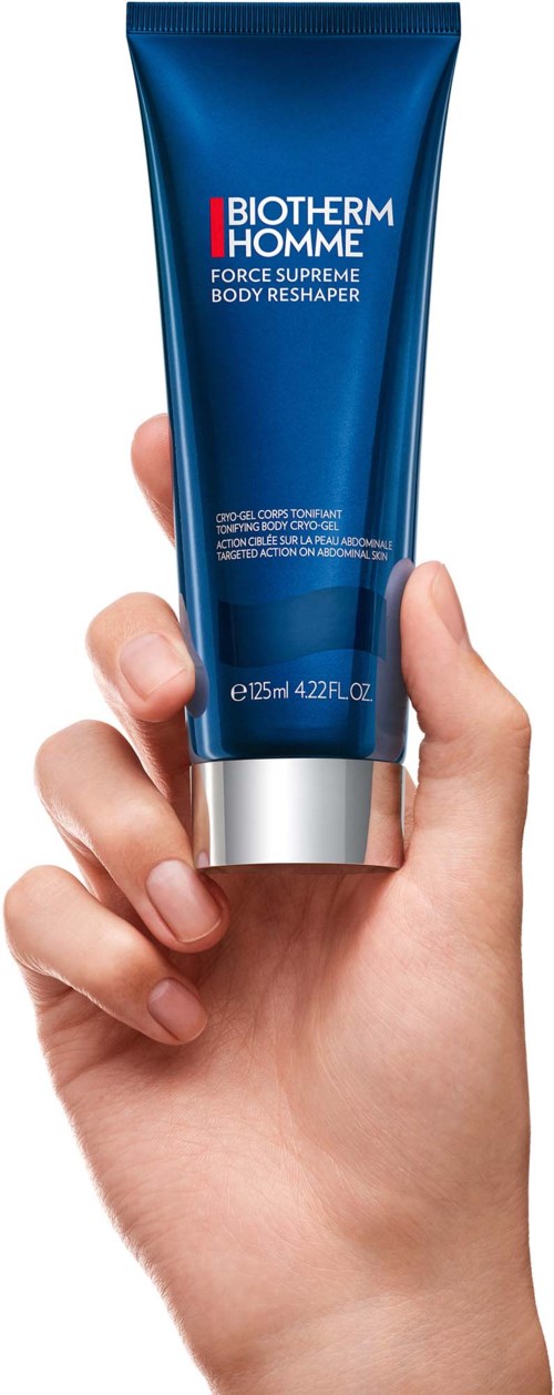 En hand håller i en blå tub med Biotherm Homme Force Supreme Body Reshaper hudvårdsprodukt.