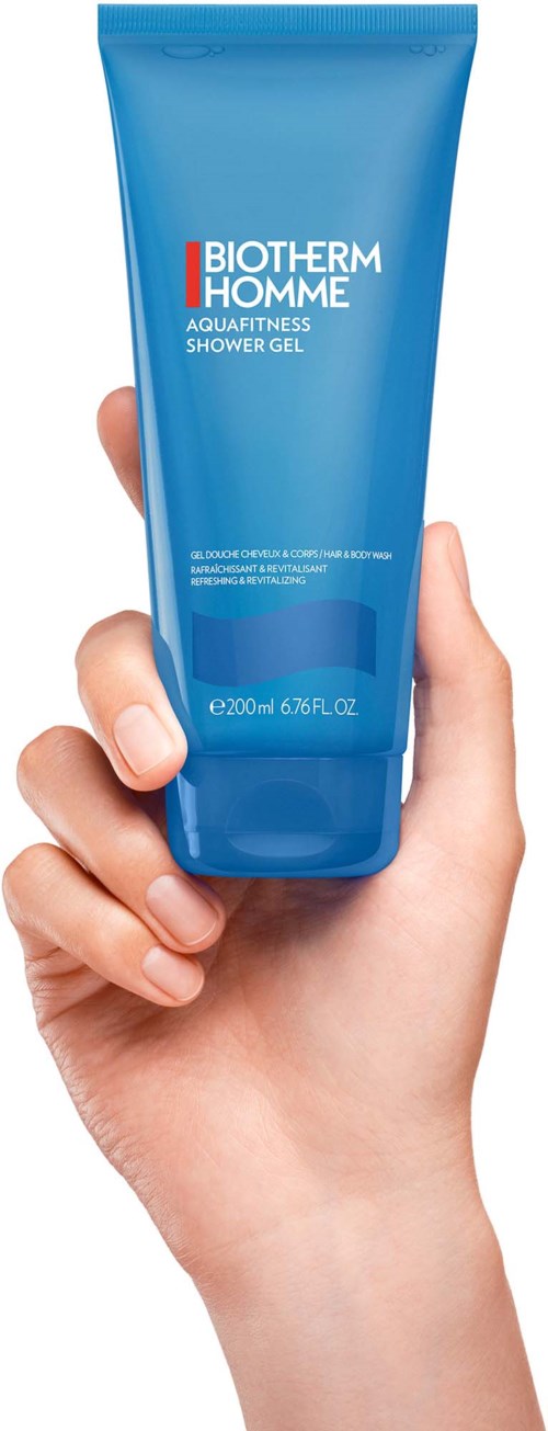 Hand hält eine blaue Tube mit Biotherm Homme Aquafitness Duschgel.