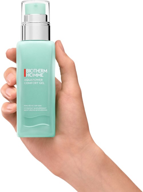 En hånd holder en lys blå flaske av Biotherm Homme Aqua Power Comfort Gel med en sølvpumpe.