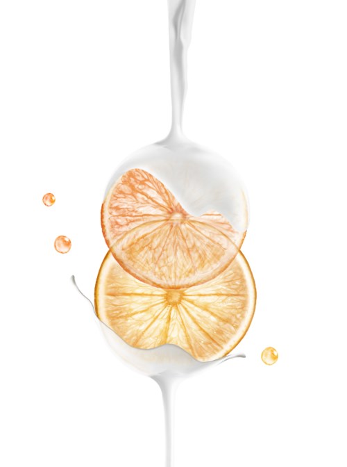 To appelsinskiver dekkes med hvit væske, sannsynligvis melk, med noen dråper i nærheten.
