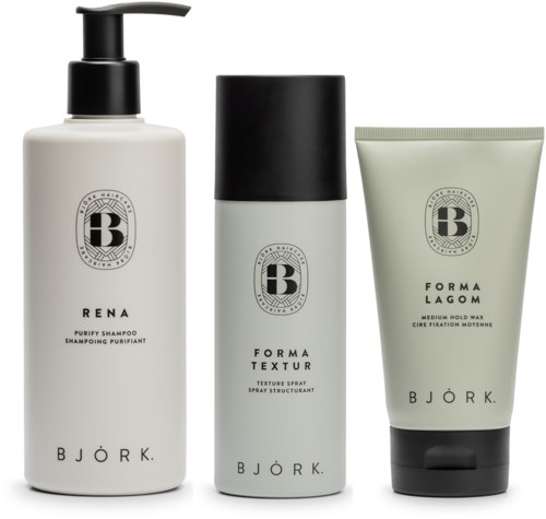 Tre Björk hårvårdsprodukter: schampo, spray och vax i flaskor och en tub med svarta och grå design.