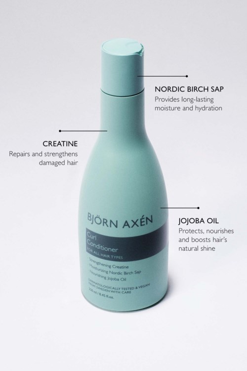 Butelka od Bjorn Axen, zawiera odżywkę do włosów z składnikami takimi jak nordycki sok z brzozy, kreatyna i jojoba.