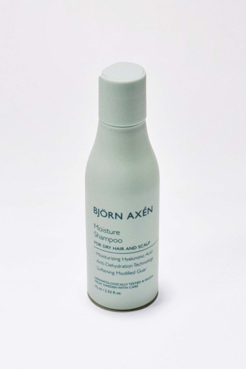 Vit flaska med Björn Axén Moisture Shampoo för torrt hår och hårbotten, med enkel design.