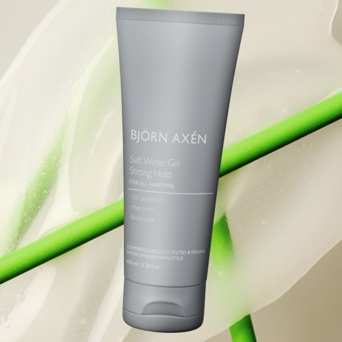 A grey tube of Björn Axén Salt Water Gel on a surface with a green stick and some white liquid.