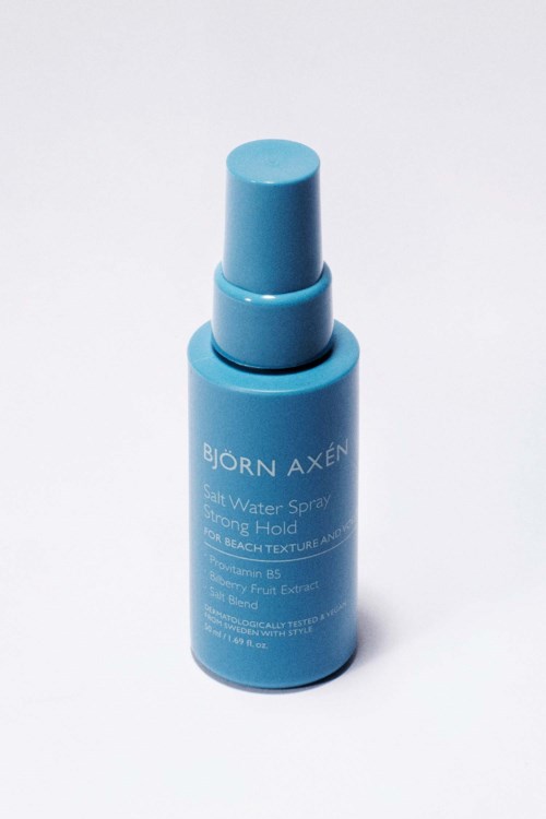 Blå sprayflaska märkt Bjorn Axen Salt Water Spray för stark hold.