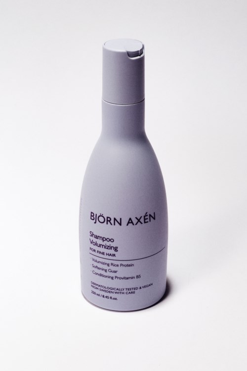 En vit flaska Björn Axén-shampoo står mot en vit bakgrund.