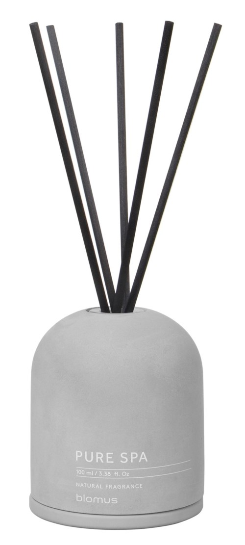 A white round aroma diffuser with black sticks coming out, labeled 'Pure Spa' for relaxation and scent.