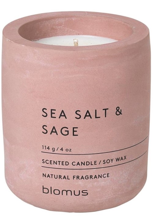 A pink candle labeled 'Sea Salt & Sage' with natural fragrance and soy wax in a round container.