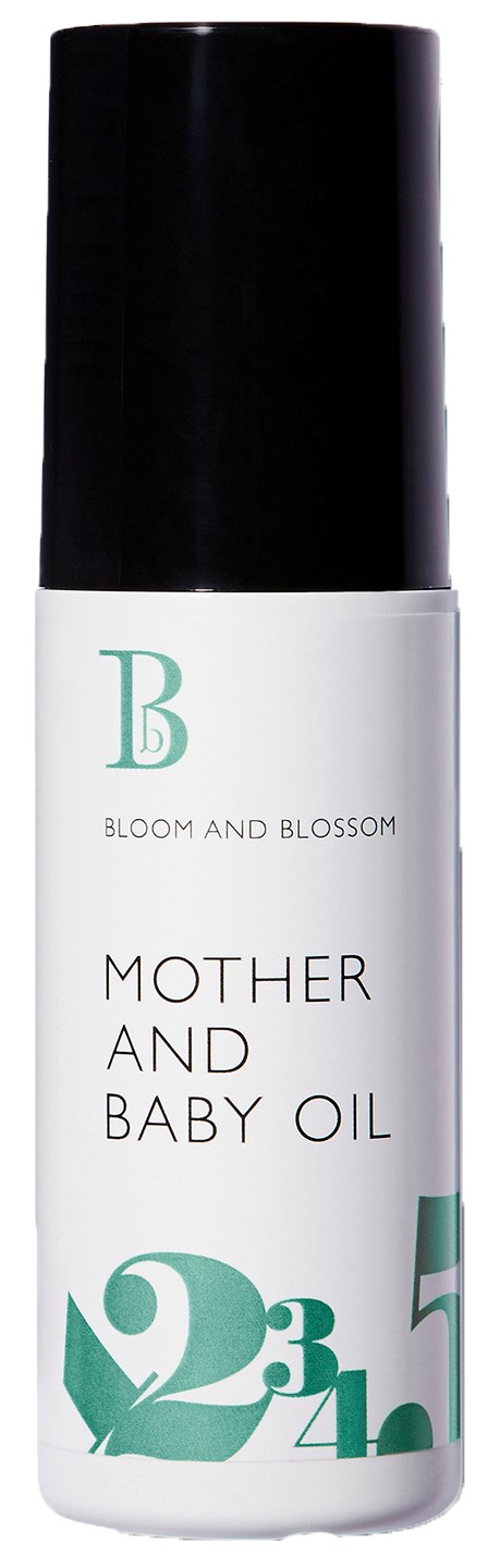 En flaska märkt 'Mother and Baby Oil' med svart lock, vit och grön design och märket 'Bloom and Blossom.'