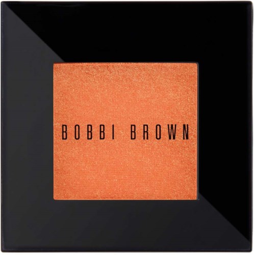 En svart fyrkantig makeup-kompakt med rouge i orangefärgad nyans och svart text som säger "BOBBI BROWN".