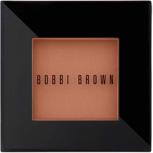 En kvadratisk Bobbi Brown makeup-produkt i en svart låda, visar en peachy-bink nyans inuti.