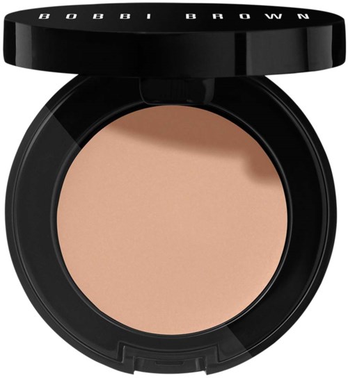 En rund behållare med beige puder, lock som säger 'BOBBI BROWN'.