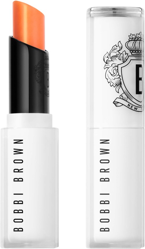 En läppstift och dess genomskinliga fodral med svartvit Bobbi Brown-vara. Läppstiftet är orange och något spetsigt.