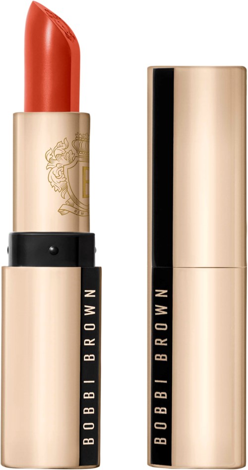 En läppstift med guldig och svart förpackning, delvis öppen för att visa röd läppstift. Lipstiftet är från Bobbi Brown.