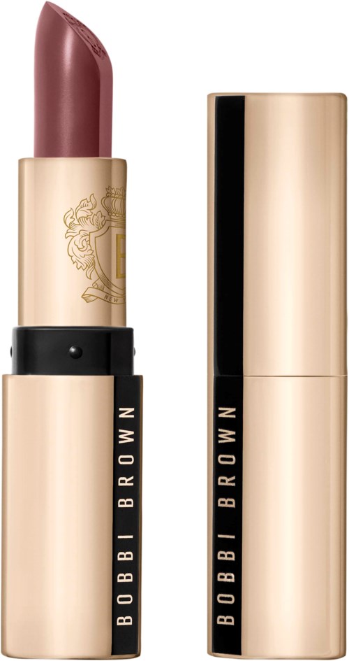 A lipstick in a gold tube with black band and logo, with the cap off showing the mauve-bink color.
