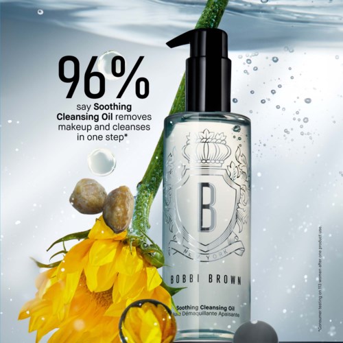 A skincare product bottle with a pump, yellow flowers, green plant, and water droplets, highlighting its soothing cleansing oil.