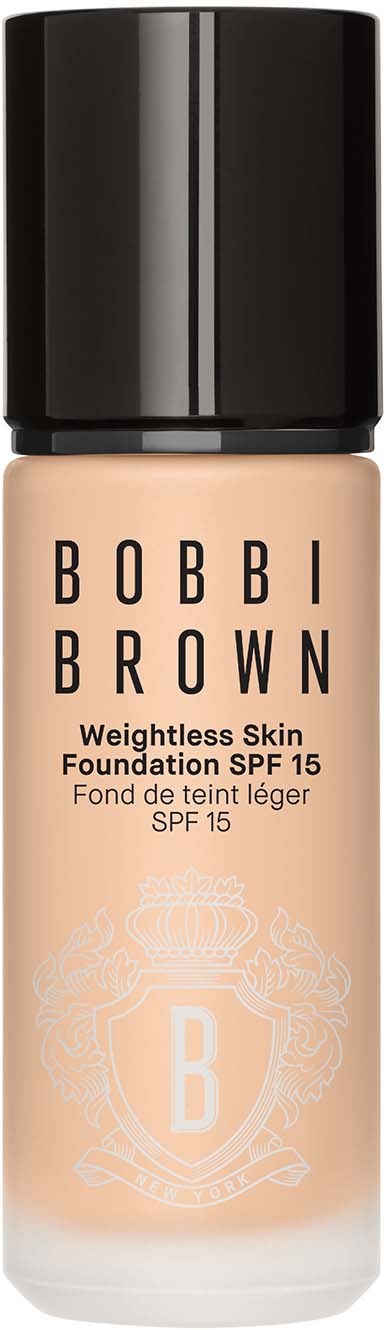 En foundationflaska med svart lock, ljusbeige färg och varumärket Bobbi Brown.