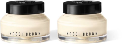 To krukker med Bobbi Brown-creme med sorte låg står side om side på sort baggrund.