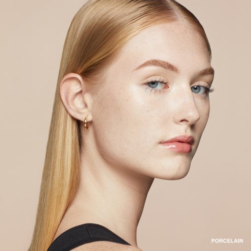 A young woman with long, straight blonde hair, blue eyes, and a light skin tone. She has a subtle makeup look.