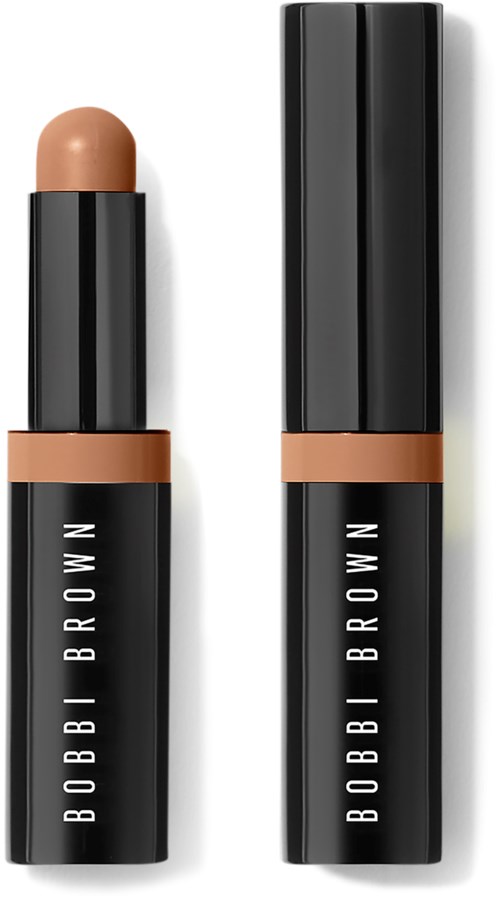 Eine schwarze Lippenstifthülse mit offenem Deckel, beige Lippenstift sichtbar. Der Produktname ist Bobbi Brown.
