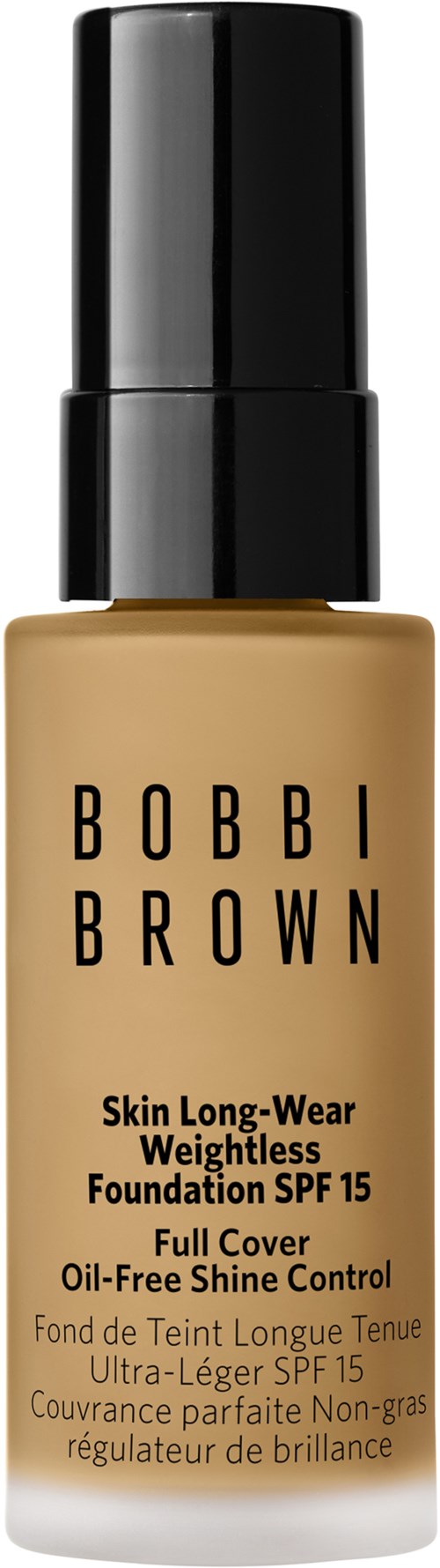 En beige foundationflaska med svart lock, märkt 'Bobbi Brown', som ger hållbar, oljefri täckning och SPF 15.