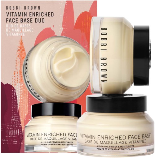 Three jars of Bobbi Brown vitamin-enriched face base with black lids and a colorful background. The open jar shows cream.
