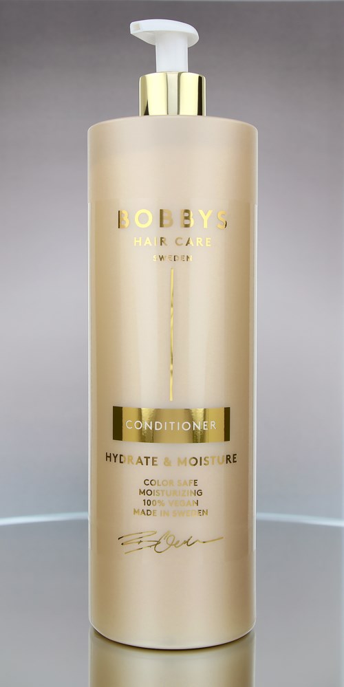 Een lange, beige fles met pomp. Gouden accenten en de tekst 'BEBYS Hair Care' en 'CONDITIONER'.