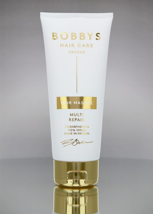 Een witte tube van Bobby's Hair Care haarmasker met goudaccenten, gemarkeerd 'Multi Repair' voor versterking en herstel.
