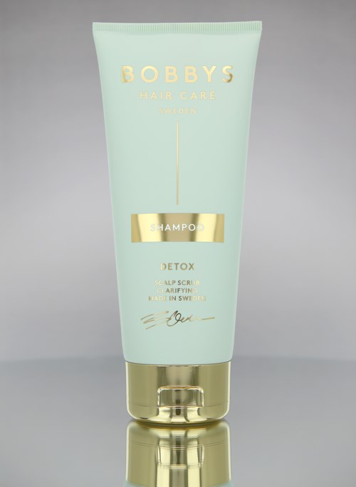 En ljusgrön flaska med Bobby's Hair Care Detox-schampo med gyllene detaljer och enkel text.