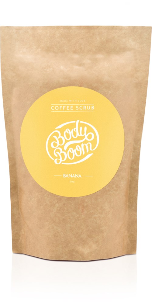 En brun papirpose med en gul sirkulær etikett som sier 'Body Boom Coffee Scrub Banana'.