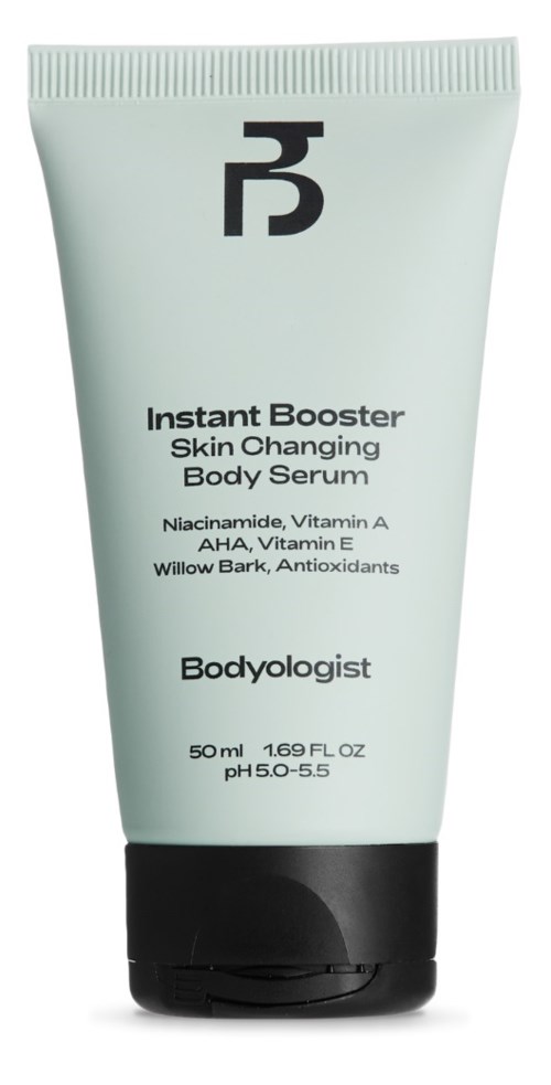 A pale green tube of body serum with black and white text, labeled as Instant Booster Skin Changing Body Serum.