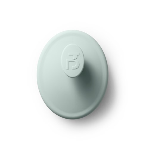 A round, light-colored object with a logo or symbol on the top surface.