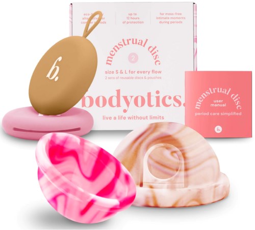Mensskivor med rosa och beige marmorerade mönster, paketerade i en box och liten bok, för mensskydd.