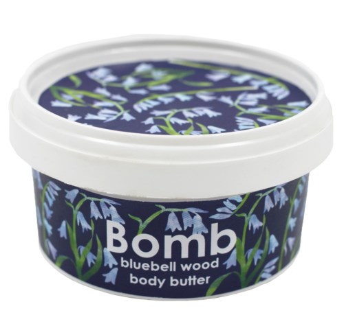 En burk med kroppssmörjning med blåklocka blomstermotiv, vit lock och namnet 'Bomb' på etiketten.