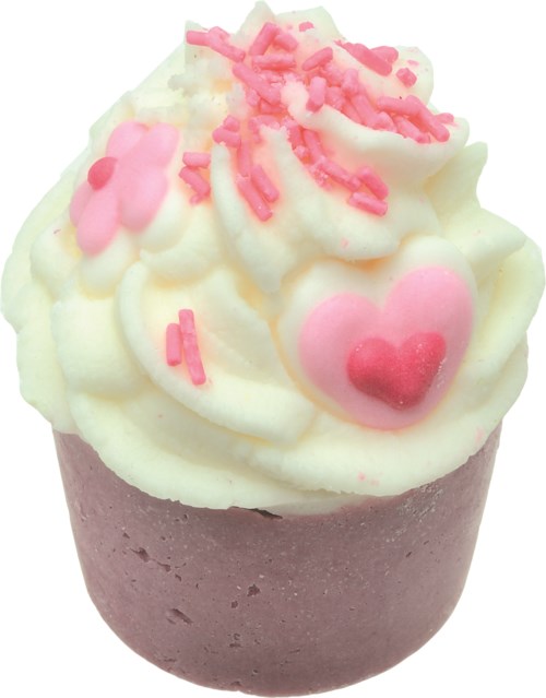 Kage med pink og rød hjerteformet pynt og lyserødt drys på hvid frosting.