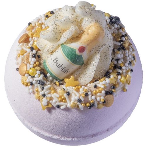 En rund kake med fargerike strøssel, pynt av champagneglass og hvit krem med glitter.