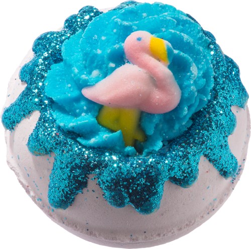 En badebombe med en rosa flamingoleke inni, omgitt av blått og hvitt med glitter.