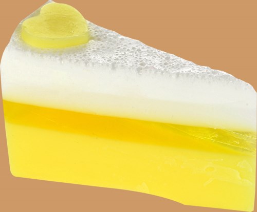 En sitronkake i skive med gule og hvite lag, toppet med en sitronskive og skum.