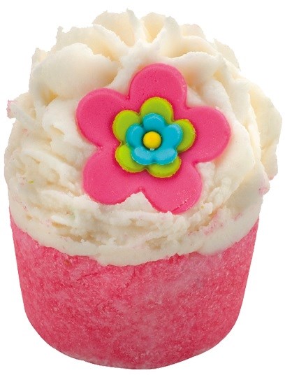 En lyserød kopcupcake med hvid frosting og en farverig blomsterdekoration på toppen.