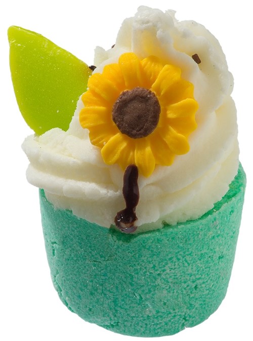 En farverig cupcake med grøn frosting, hvid flødeskum, en gul blomsterdekoration og en grøn skive.