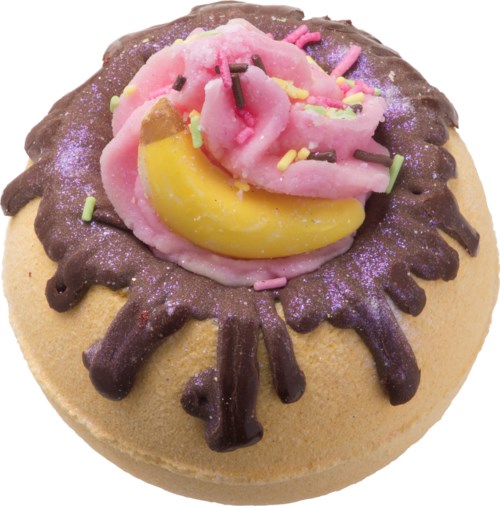 En rund kake med rosa og gul glasur, sjokoladestriper og fargerikt strøssel på toppen.