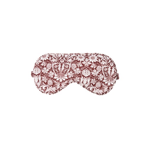 En rosa sovmask med blomsterfärgat mönster och stängda ögon.