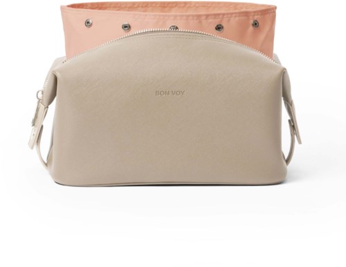 Två beige och rosa väskor staplade, en med metallhål och orden 'BON VOY' på sig.