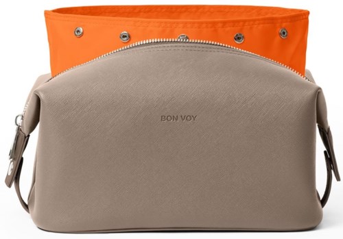 Två väskor staplade, beige framväskan med 'BON VOY' text, orange toppväska med knäppknappar.