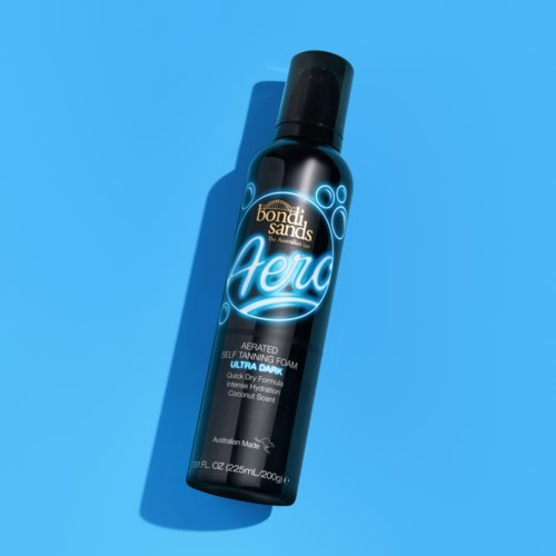 A black spray bottle labeled 'Bondi Sands Aero' self-tanning foam, with blue and white text, on a blue background.
