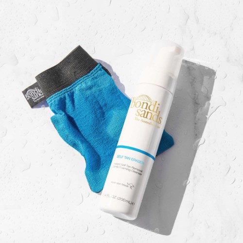 A blue sock, a white foam spray bottle, and water droplets on a white surface.