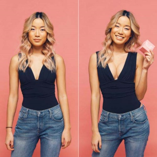 Two women with long, wavy blonde hair wear black tops and jeans against a pink background, smiling and holding a pink box.